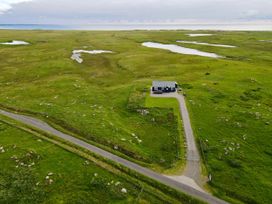 A house with a driveway in a field at Taigh Gorm Baleshare near Balivanich
