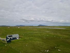 A house with solar panels near a field at Taigh Gorm Baleshare near Balivanich
