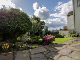 A garden with flower beds shrubs a stone pathway and a garden shed at Style Cottage in Keswick