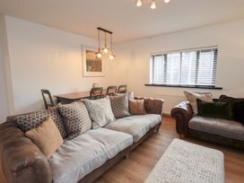 A living room with a sofa and dining table at Glen Lea in Giggleswick, Settle