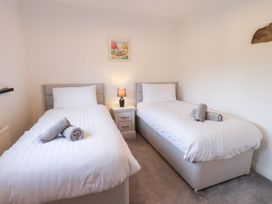 A bedroom with two beds and a nightstand at Glen Lea in Giggleswick, Settle