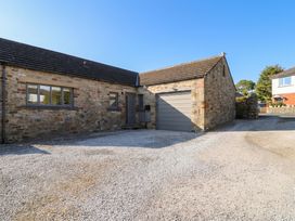 A stone building with a garage and gravel driveway at Glen Lea in Giggleswick, Settle