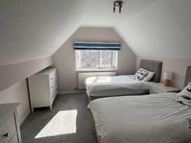 A bedroom with two beds and a dresser at Swn Y Mor in Benllech