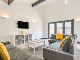 A living room with a sofa, coffee table and television at The Cottage in Wimborne Minster