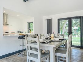 A dining area featuring a table with chairs and a bar stool at The Cottage in Wimborne Minster