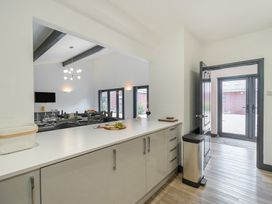 A kitchen with a kitchen island and stools at The Cottage in Wimborne Minster
