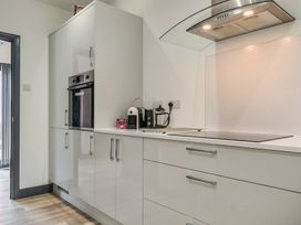 A kitchen with cabinets, a coffee maker, and an oven at The Cottage in Wimborne Minster