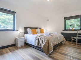 A bedroom with a bed and windows at The Cottage in Wimborne Minster