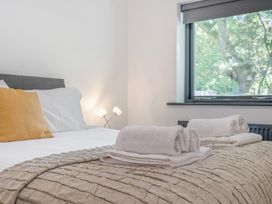 A bedroom with a bed and towels on the blanket at The Cottage in Wimborne Minster