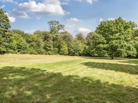 A grassy area surrounded by trees at The Cottage in Wimborne Minster