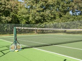 A tennis court with rackets and balls at The Cottage in Wimborne Minster