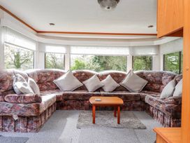 A living room with a sofa and coffee table at Fron Dderw Caravan Llanfairynghornwy near Llanfechell