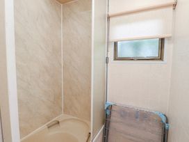 A bathroom with a shower and bathtub at Fron Dderw Caravan in Llanfairynghornwy near Llanfechell