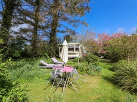 A garden with a caravan and seating area at Fron Dderw Caravan Llanfairynghornwy near Llanfechell