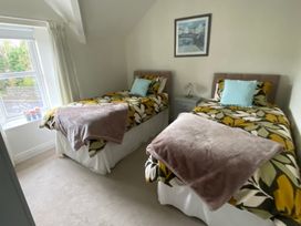 A bedroom with two single beds and a window at 4 The Cloisters in Bushmills, County Antrim