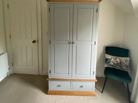 A wardrobe and chair in a bedroom at 4 The Cloisters, Bushmills, County Antrim
