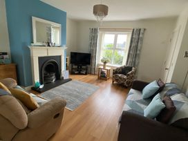 A living room with a fireplace and television at 4 The Cloisters in Bushmills, County Antrim