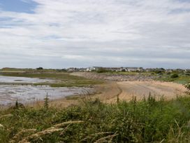 A beach view with water and houses at Harbour Retreat in Haverigg