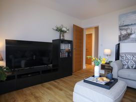 A living room with a television, couch, and coffee table at Apartment 3 in Trearddur Bay