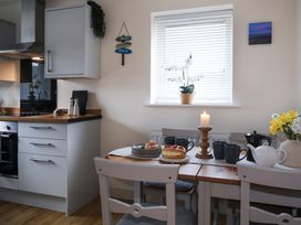 A kitchen with a table set for tea at Apartment 3 in Trearddur Bay