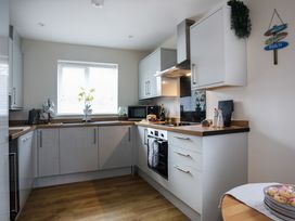 A kitchen with cabinets and oven at Apartment 3 in Trearddur Bay