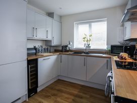 A kitchen with cabinets, a sink, and a microwave at Apartment 3 in Trearddur Bay