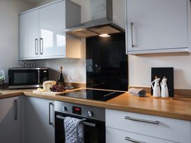 A kitchen with various appliances and items at Apartment 3 in Trearddur Bay