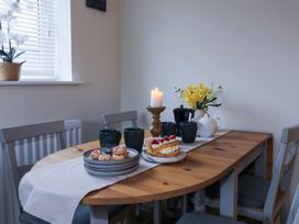 A dining room with a table set for tea at Apartment 3 Trearddur Bay