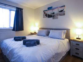 A bedroom with a bed and towels at Apartment 3 in Trearddur Bay