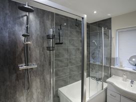 A bathroom with a shower and bathtub at Apartment 3 in Trearddur Bay
