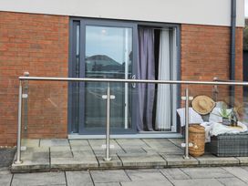An outdoor space with a glass door and seating area at Apartment 3 in Trearddur Bay