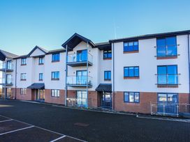 A residential building with balconies and parking area at Apartment 3 Trearddur Bay
