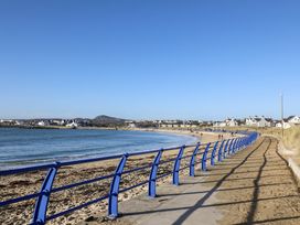 A path along the beach with houses in the background at Apartment 3 Trearddur Bay