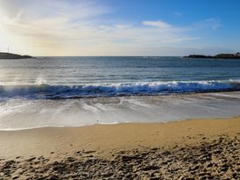 A beach with waves and sand at Apartment 3 in Trearddur Bay