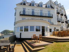An outdoor area with wooden deck and tables at 11 Cove View Apartments Ilfracombe