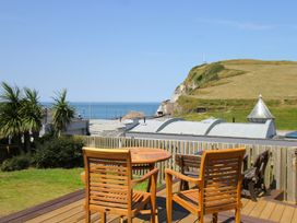 A wooden table and chairs overlooking the sea at 11 Cove View Apartments Ilfracombe