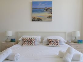 A bedroom featuring a bed with pillows and towels at 11 Cove View Apartments Ilfracombe