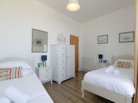 A bedroom with two beds and a dresser at 11 Cove View Apartments Ilfracombe