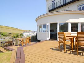 An outdoor area with a deck, table, and chairs at 11 Cove View Apartments Ilfracombe