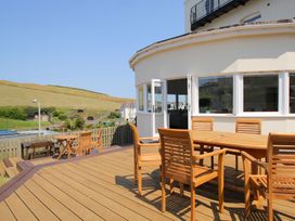An outdoor seating area with wooden furniture at 11 Cove View Apartments in Ilfracombe