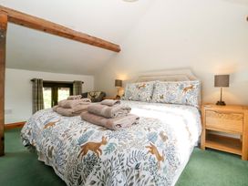 A bedroom with a bed and towels on top at Redstart Cottage in Kingsland