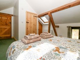 A bedroom with a bed and towels at Redstart Cottage in Kingsland