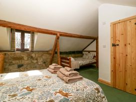 A bedroom with a bed and bunk bed at Redstart Cottage in Kingsland