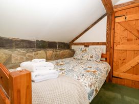 A bedroom with a bed and towels at Redstart Cottage in Kingsland