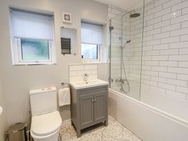 A bathroom with a sink, toilet, and shower at Treestumps in Benllech