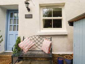 An outdoor seating area with a bench and cushions at Gwynn Cottage St Mabyn