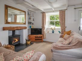 A living room with a sofa and television at Gwynn Cottage in St Mabyn