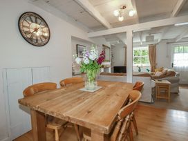 A dining room with a wooden table and chairs at Gwynn Cottage St Mabyn