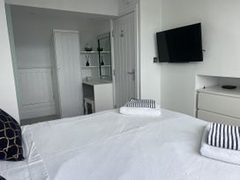 A bedroom with a bed and wardrobe at White Sails Y Felinheli