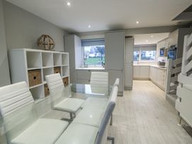 A kitchen with a dining table and chairs at White Sails in Y Felinheli